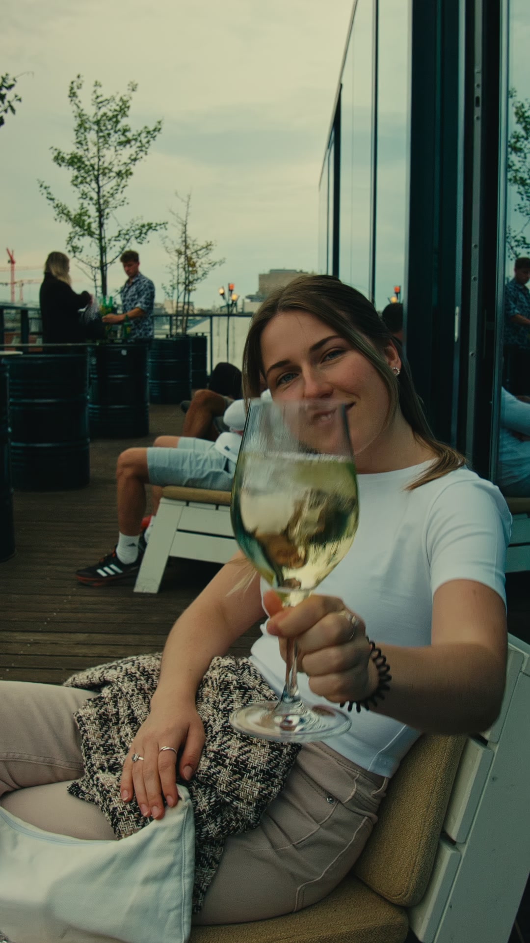 A woman raising a glass on an outdoor terrace